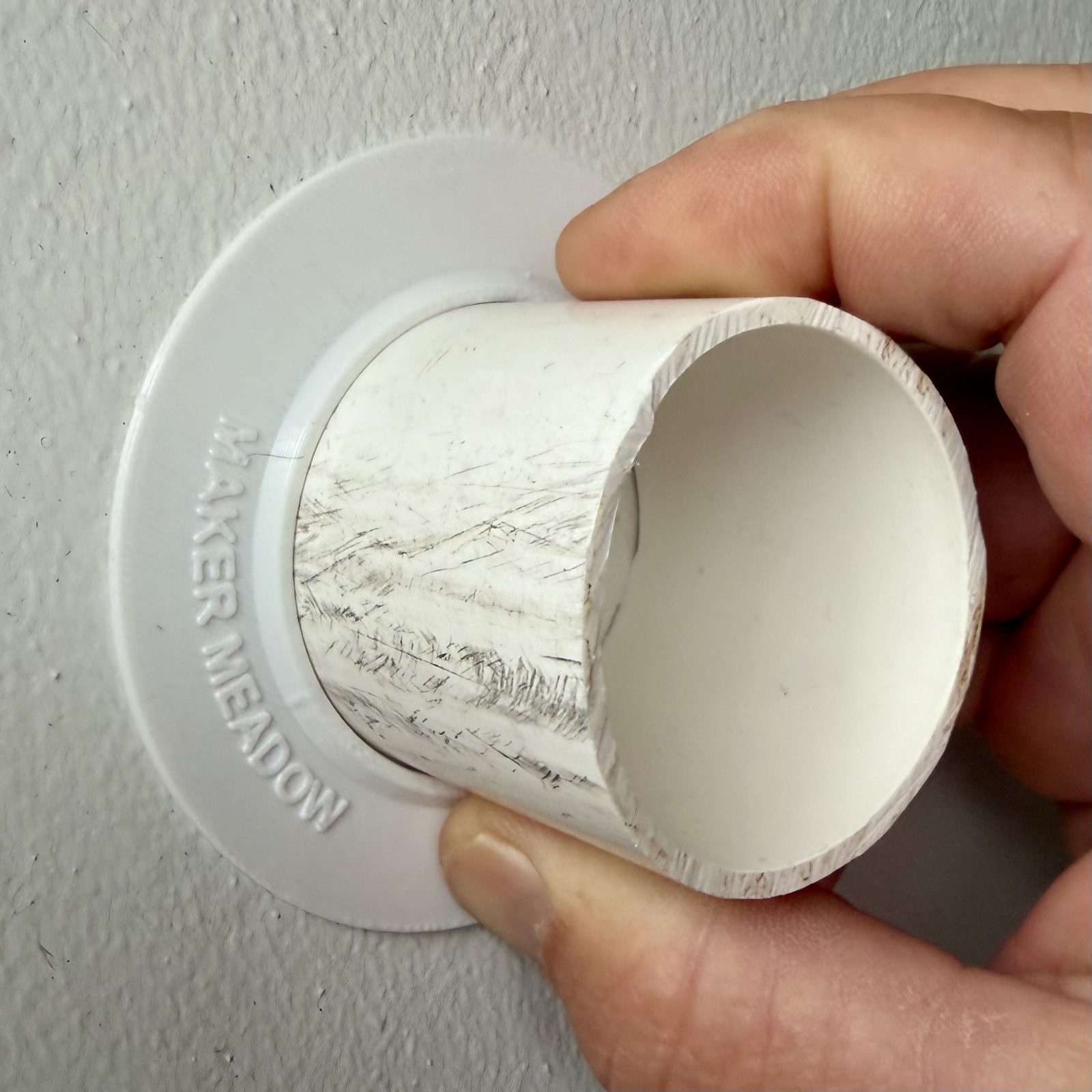 Trim-Fit wall collar held in a hand for scale